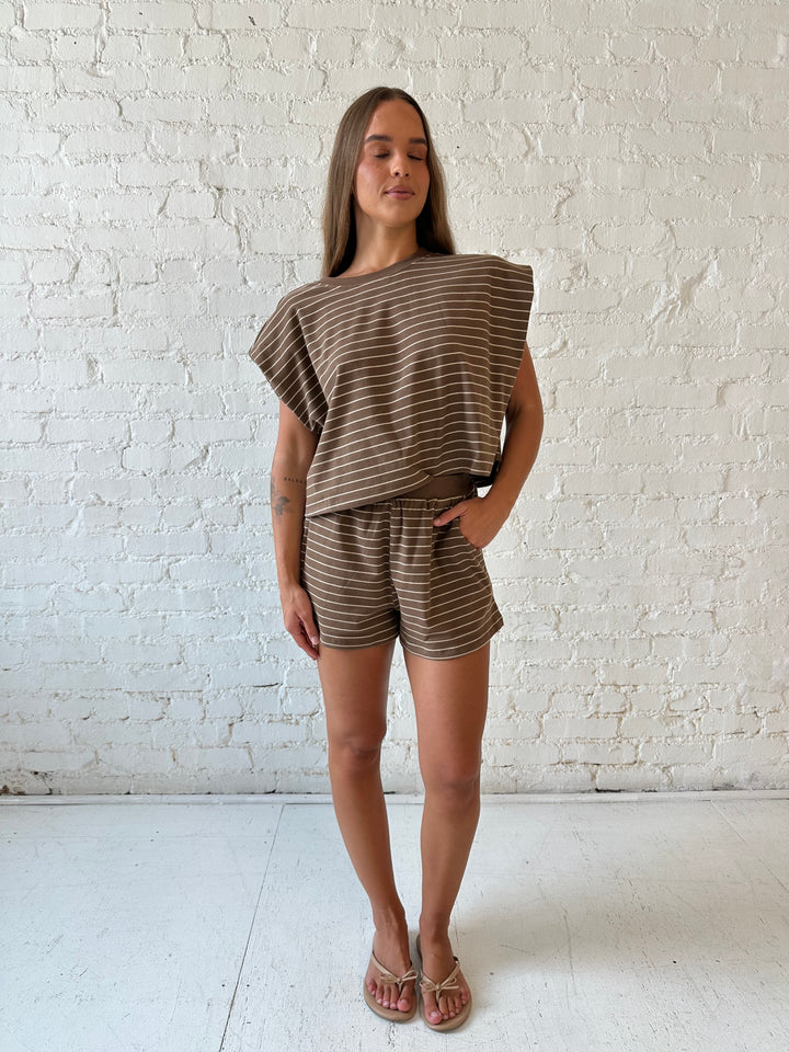 Woman wearing brown and tan striped two piece short lounge set. 