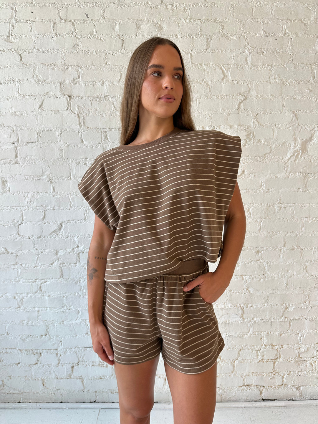 Woman wearing brown and tan striped two piece short lounge set. 