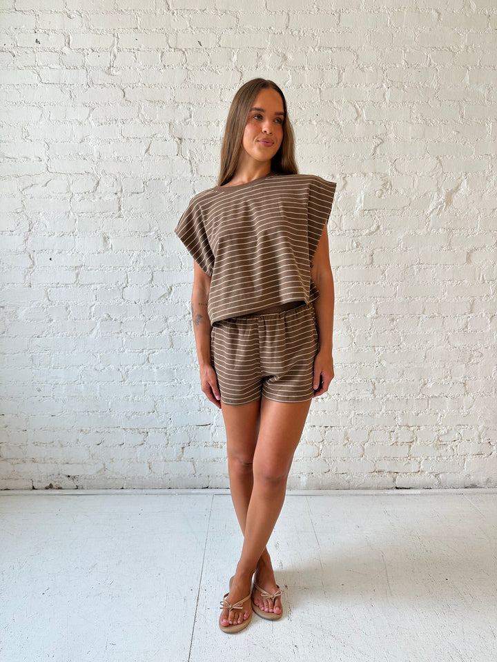 Woman wearing brown and tan striped two piece short lounge set. 