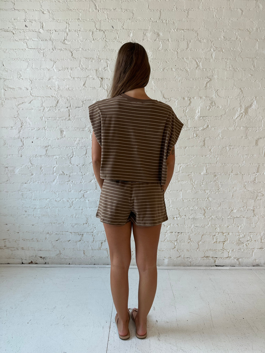 Woman wearing brown and tan striped two piece short lounge set. 