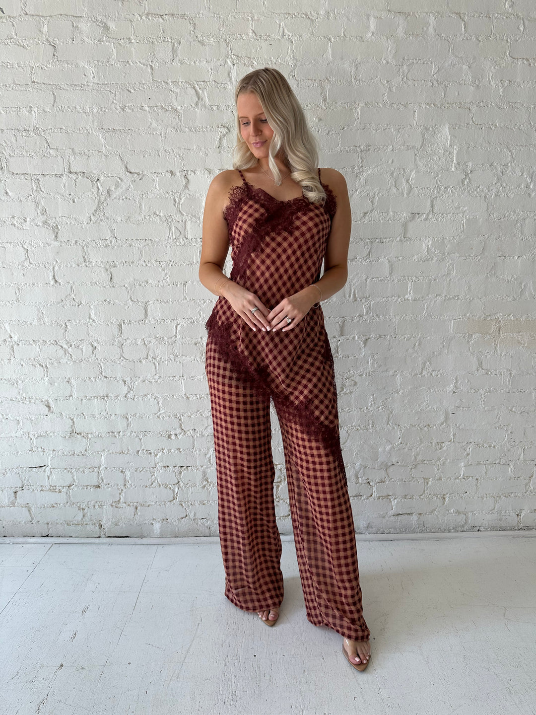 Woman wearing mauve and beige gingham two piece set with asymmetrical hem and lace trim.