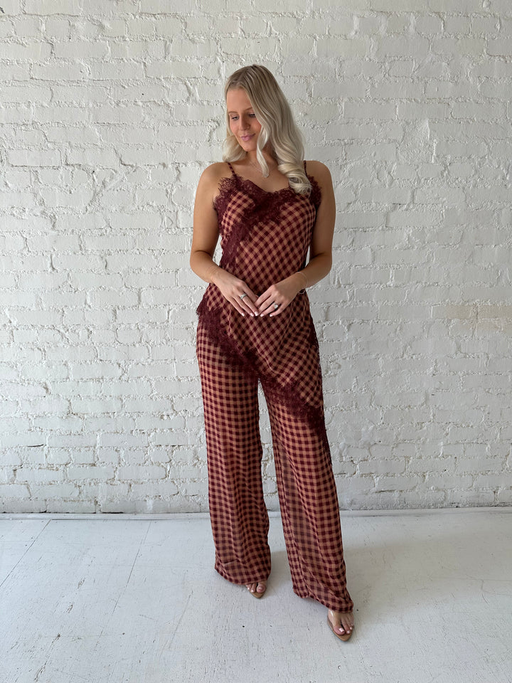 Woman wearing mauve and beige gingham two piece set with asymmetrical hem and lace trim.