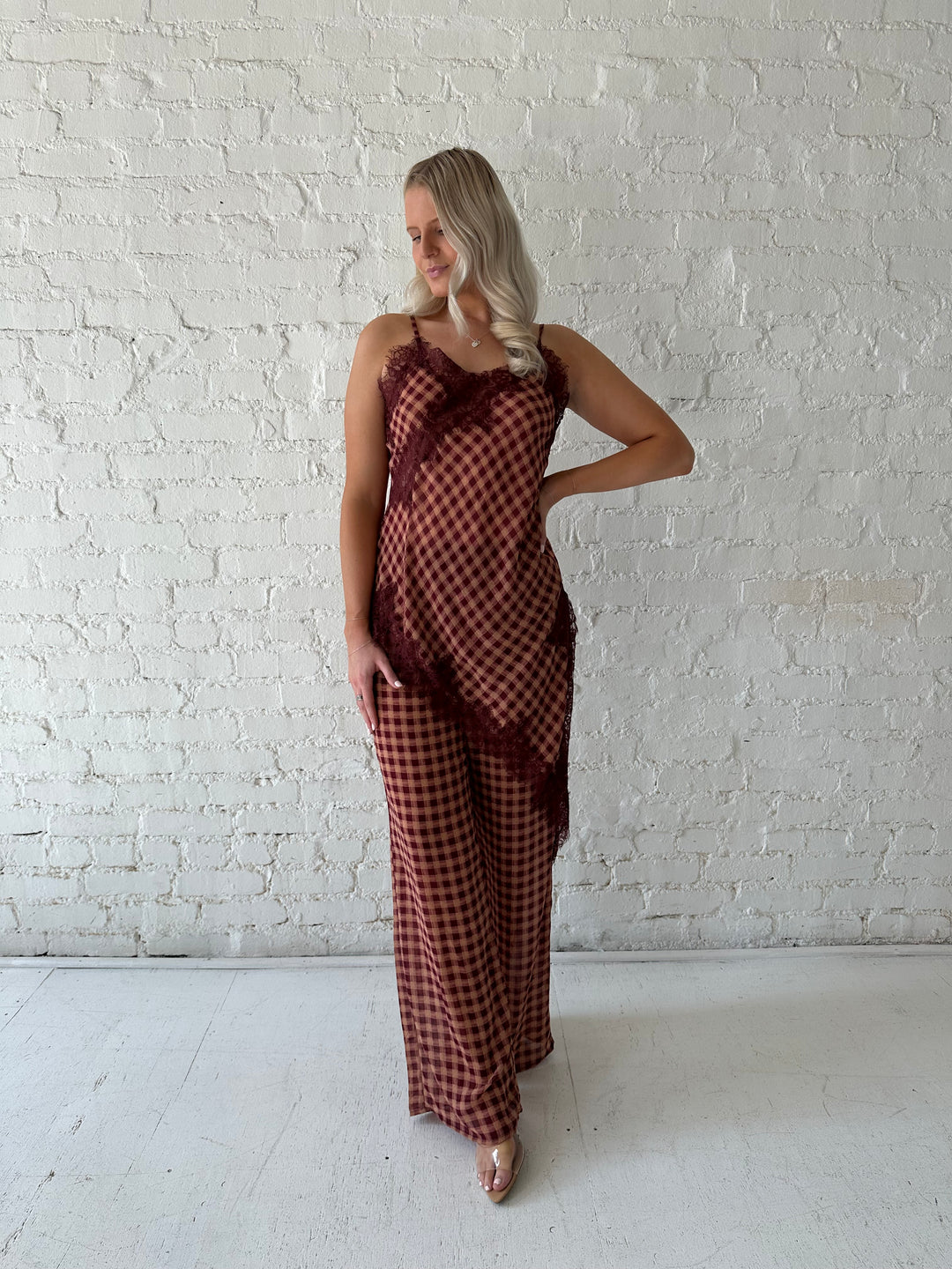 Woman wearing mauve and beige gingham two piece set with asymmetrical hem and lace trim.