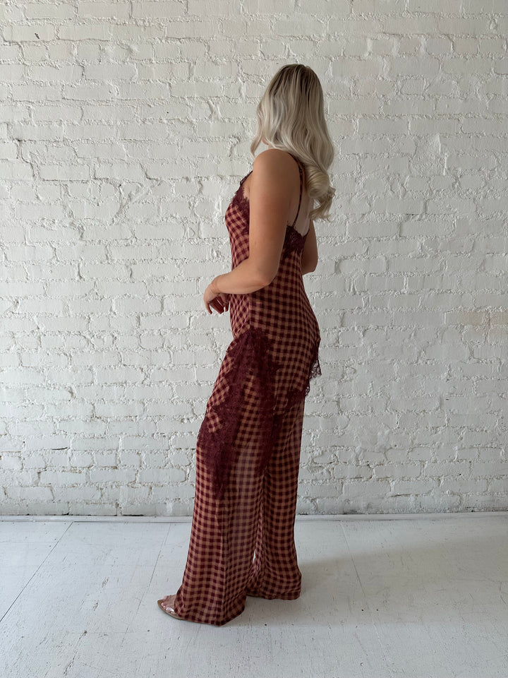 Woman wearing mauve and beige gingham two piece set with asymmetrical hem and lace trim.