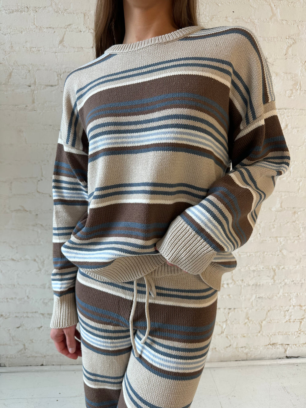 Woman neutral striped two piece knit lounge with long sleeve top, and wide leg bottom. 