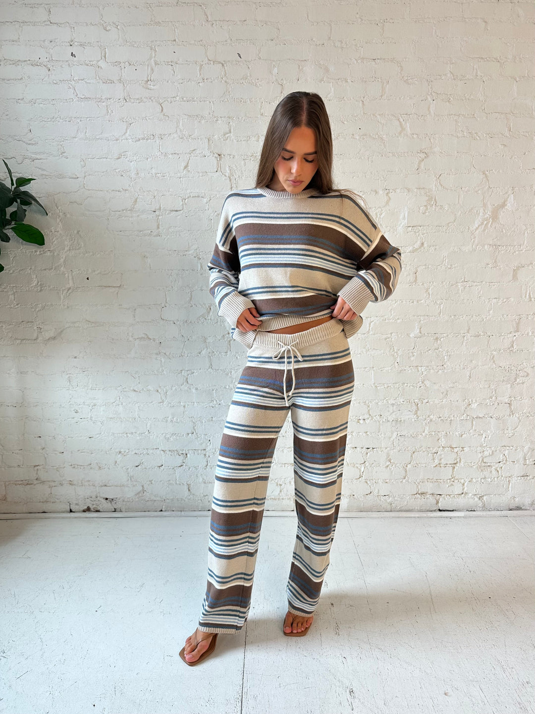 Woman neutral striped two piece knit lounge with long sleeve top, and wide leg bottom. 