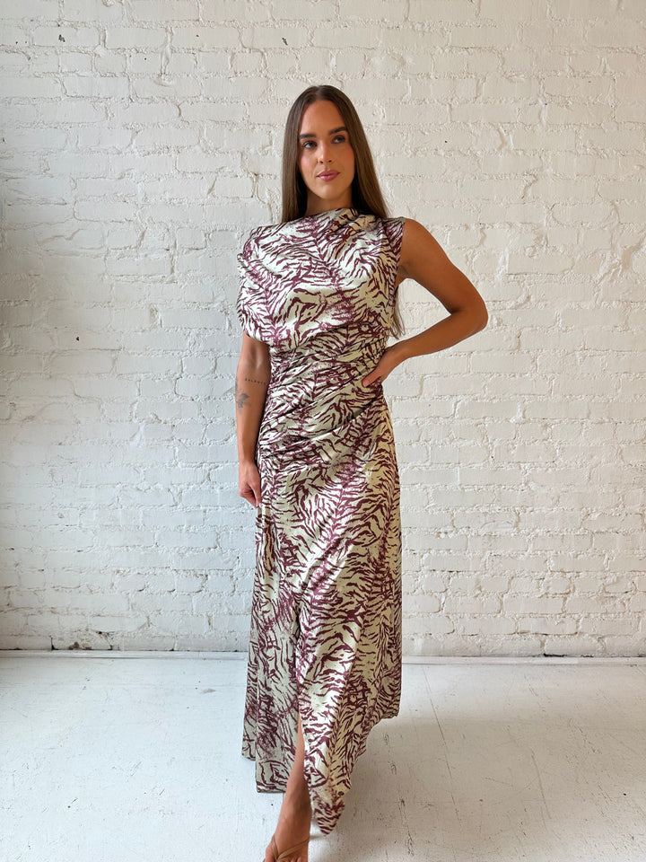 Woman wearing olive green animal print satin maxi dress with a high neckline, and side slit. 