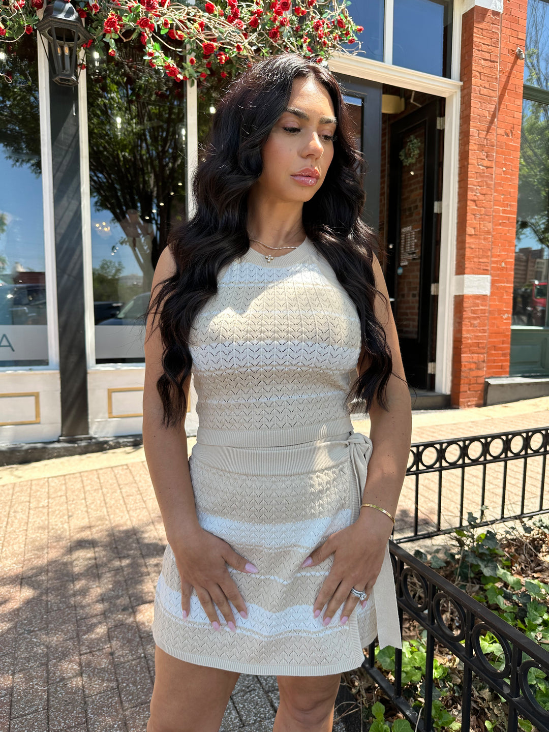 Woman wearing taupe and white striped knit two piece set with wrap skirt. 