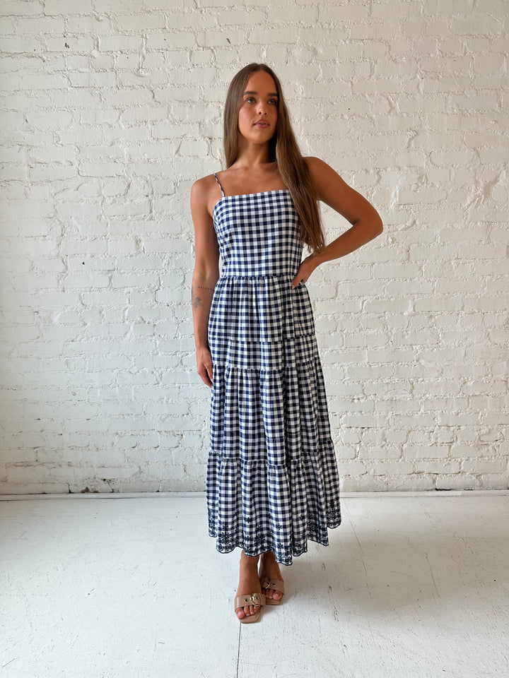 Woman wearing navy gingham midi dress with kitten heel.