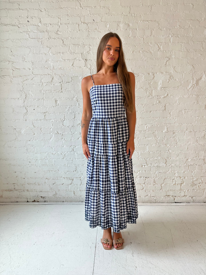 Woman wearing navy gingham midi dress with kitten heel.