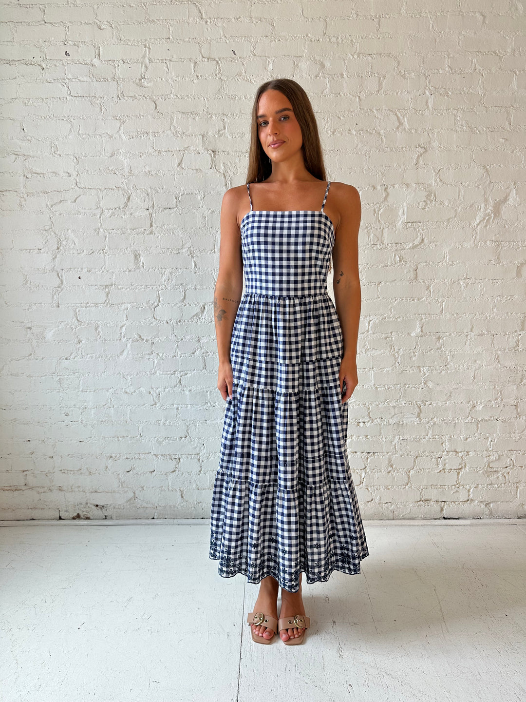 Woman wearing navy gingham midi dress with kitten heel.