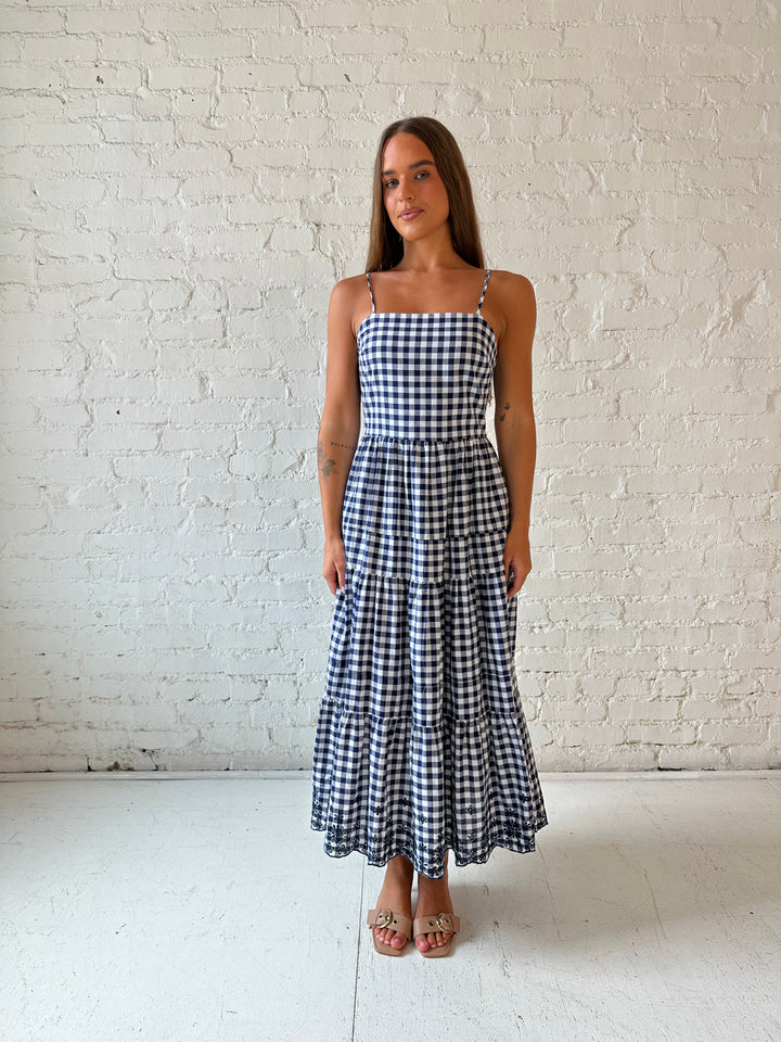 Woman wearing navy gingham midi dress with kitten heel.