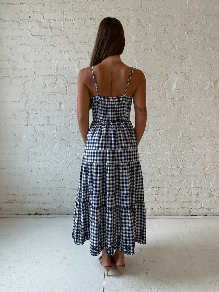 Woman wearing navy gingham midi dress with kitten heel.