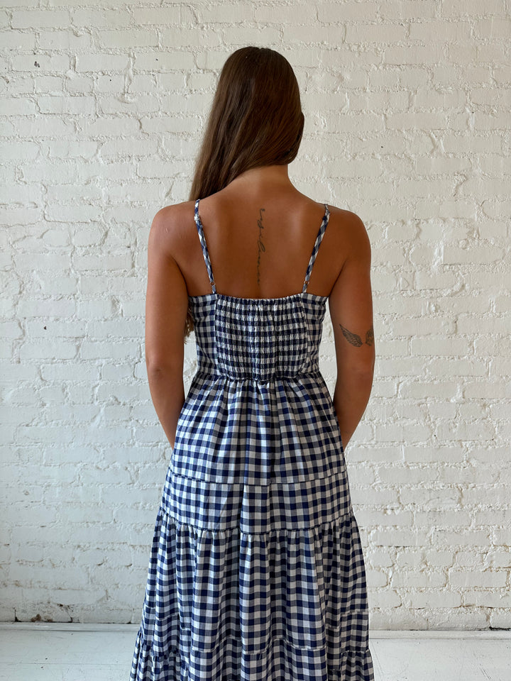 Woman wearing navy gingham midi dress with kitten heel.