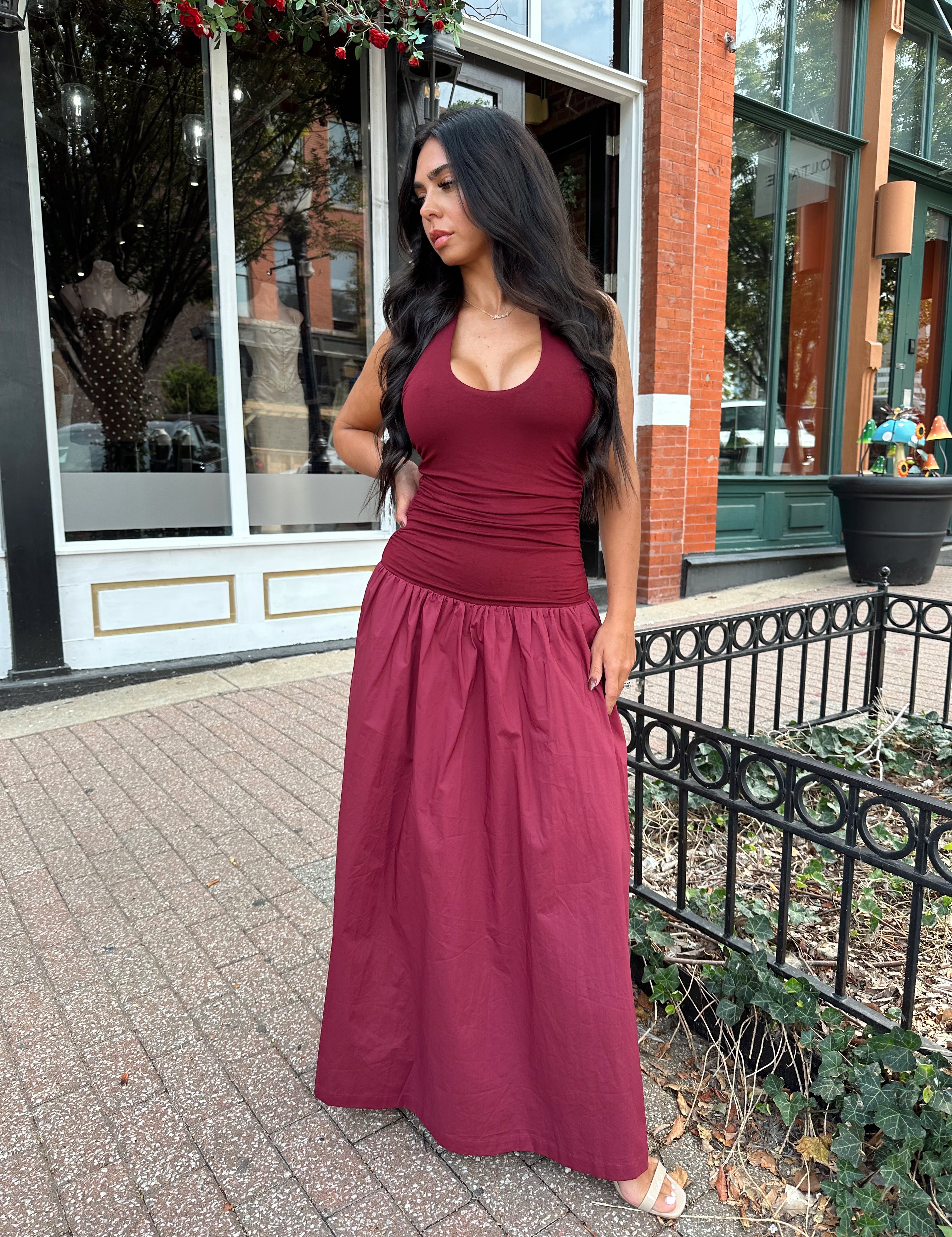 Woman wearing burgundy halter maxi dress with contrast material. 