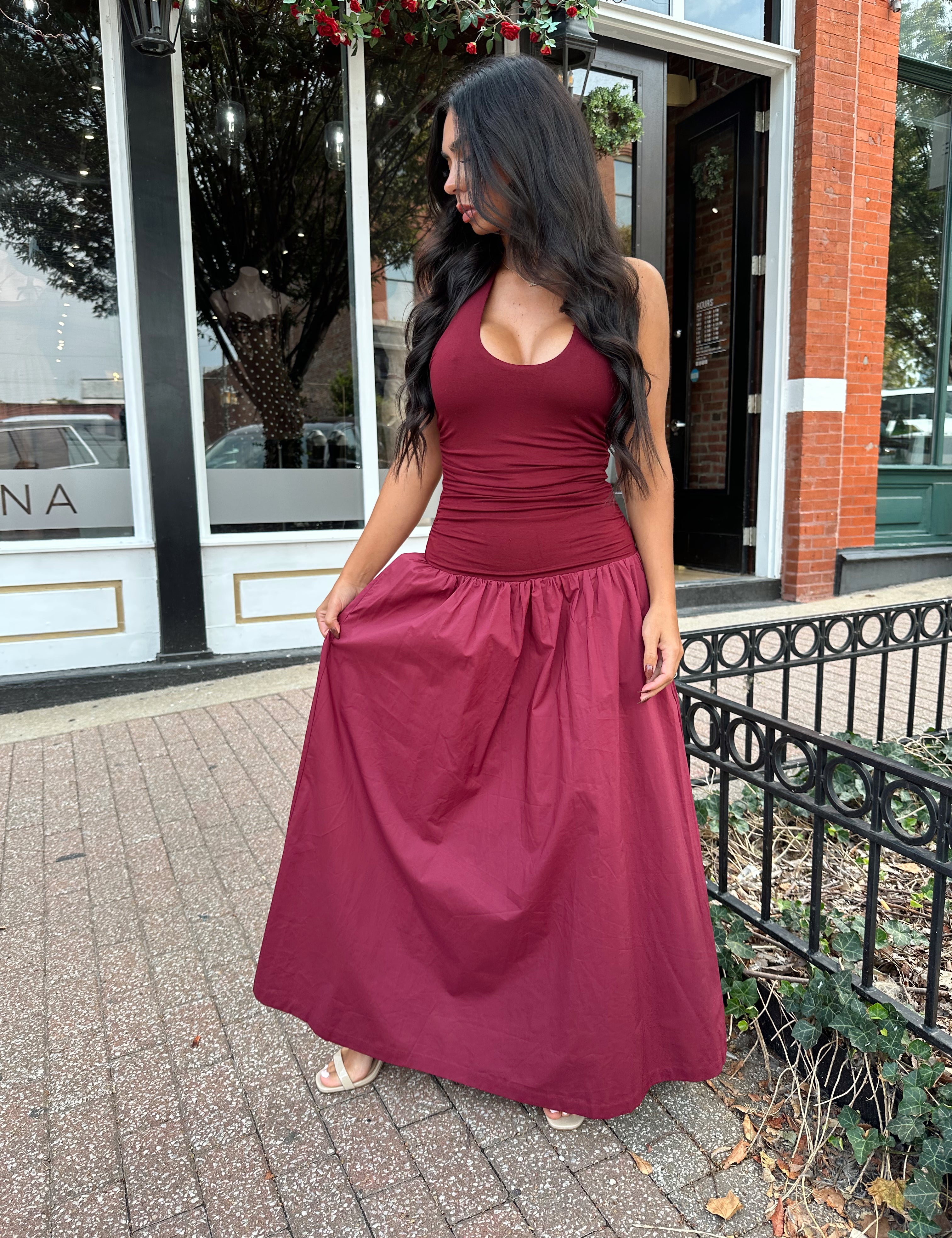 Woman wearing burgundy halter maxi dress with contrast material. 