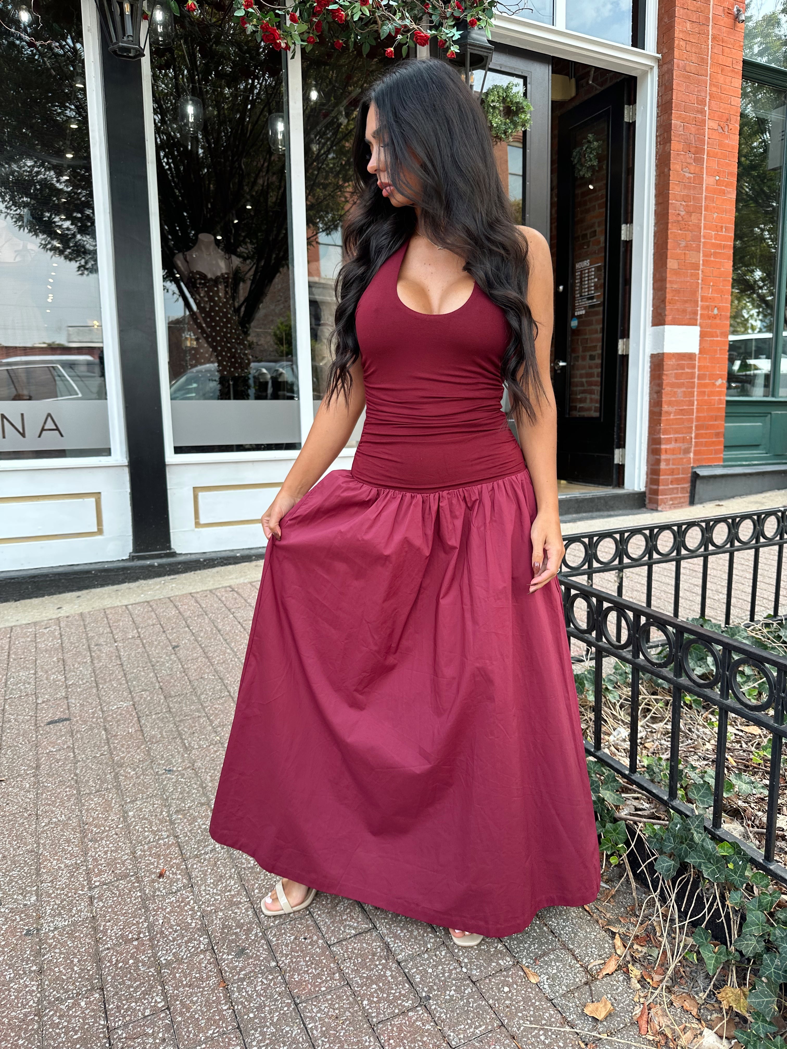 Woman wearing burgundy halter maxi dress with contrast material. 