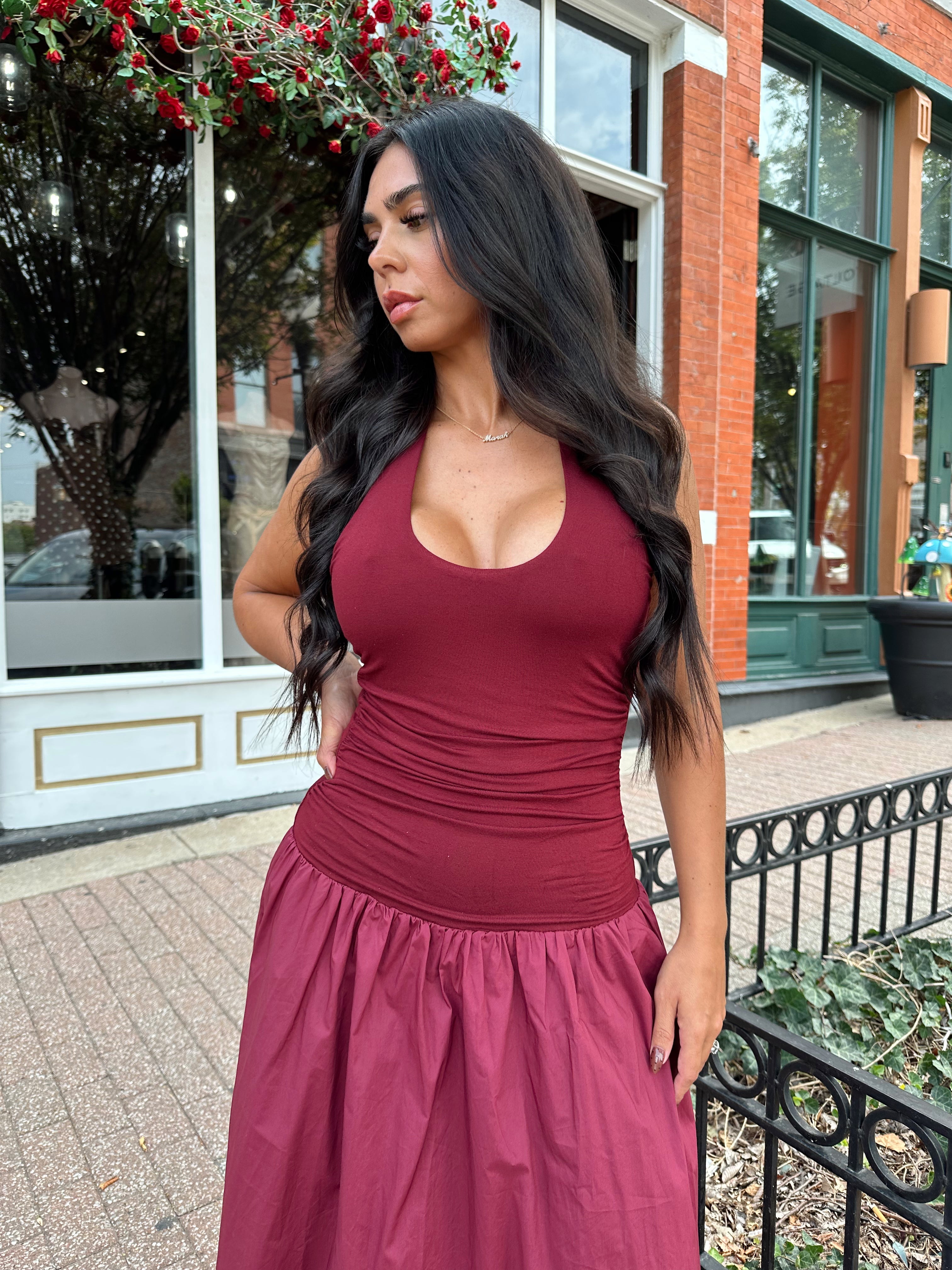 Woman wearing burgundy halter maxi dress with contrast material. 