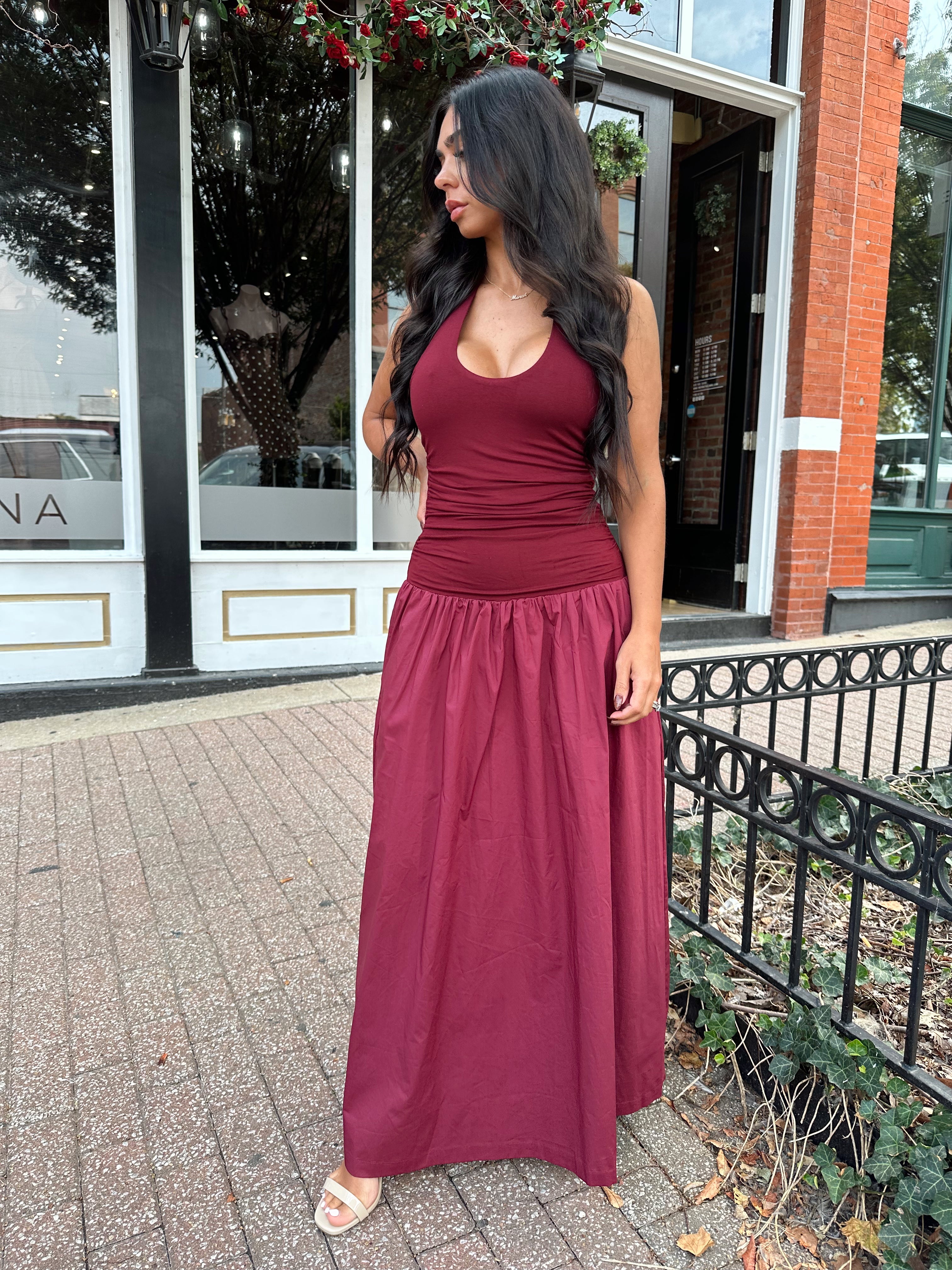 Woman wearing burgundy halter maxi dress with contrast material. 