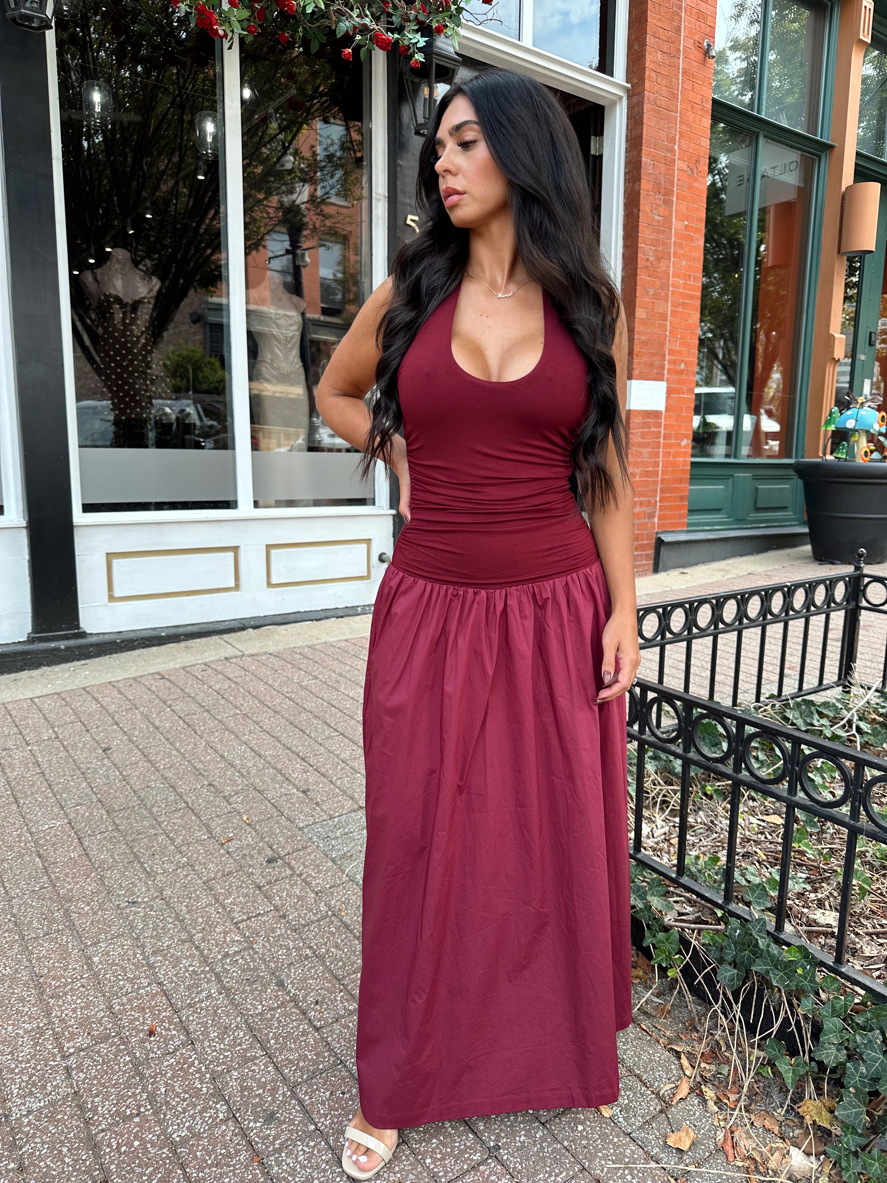 Woman wearing burgundy halter maxi dress with contrast material. 