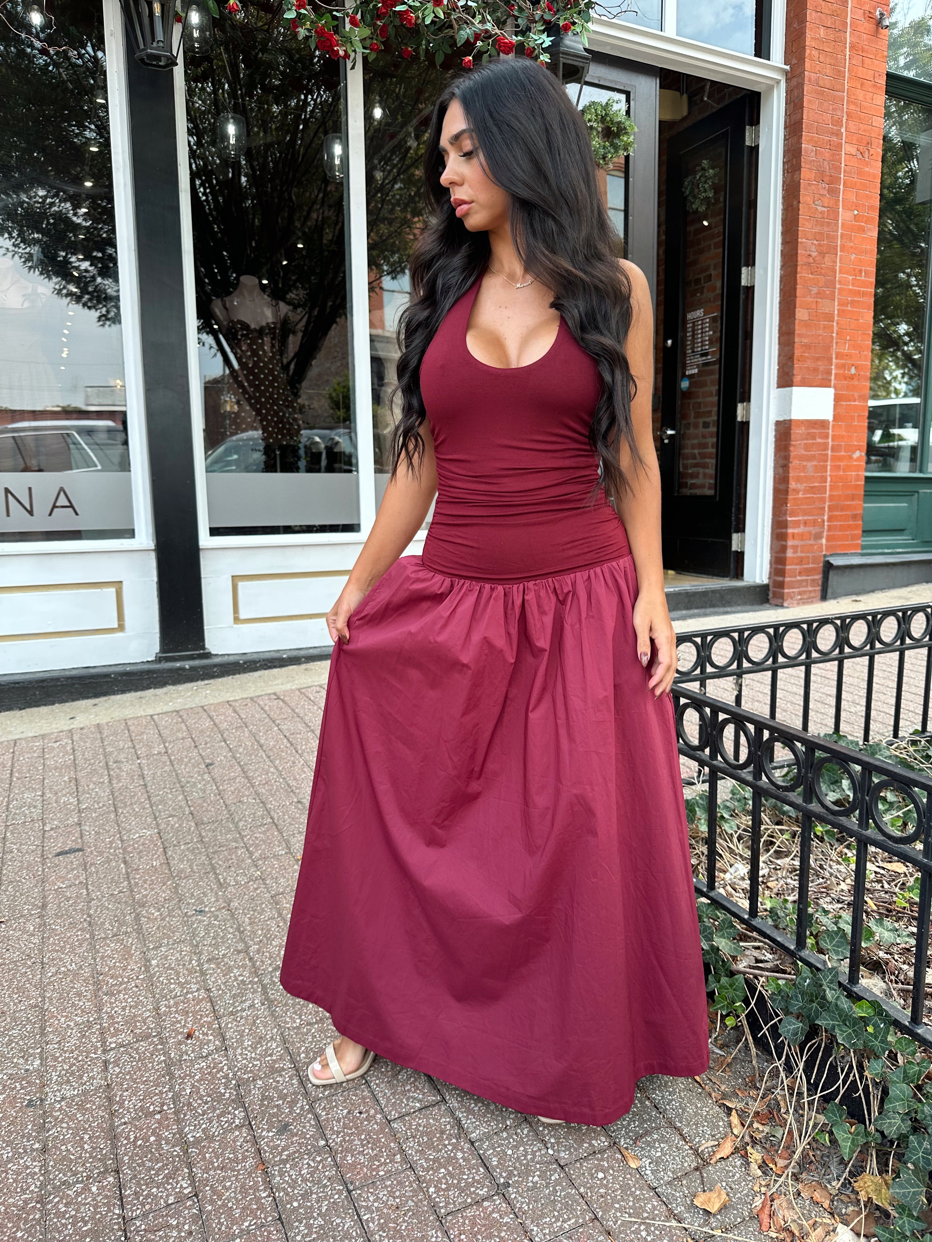 Woman wearing burgundy halter maxi dress with contrast material. 