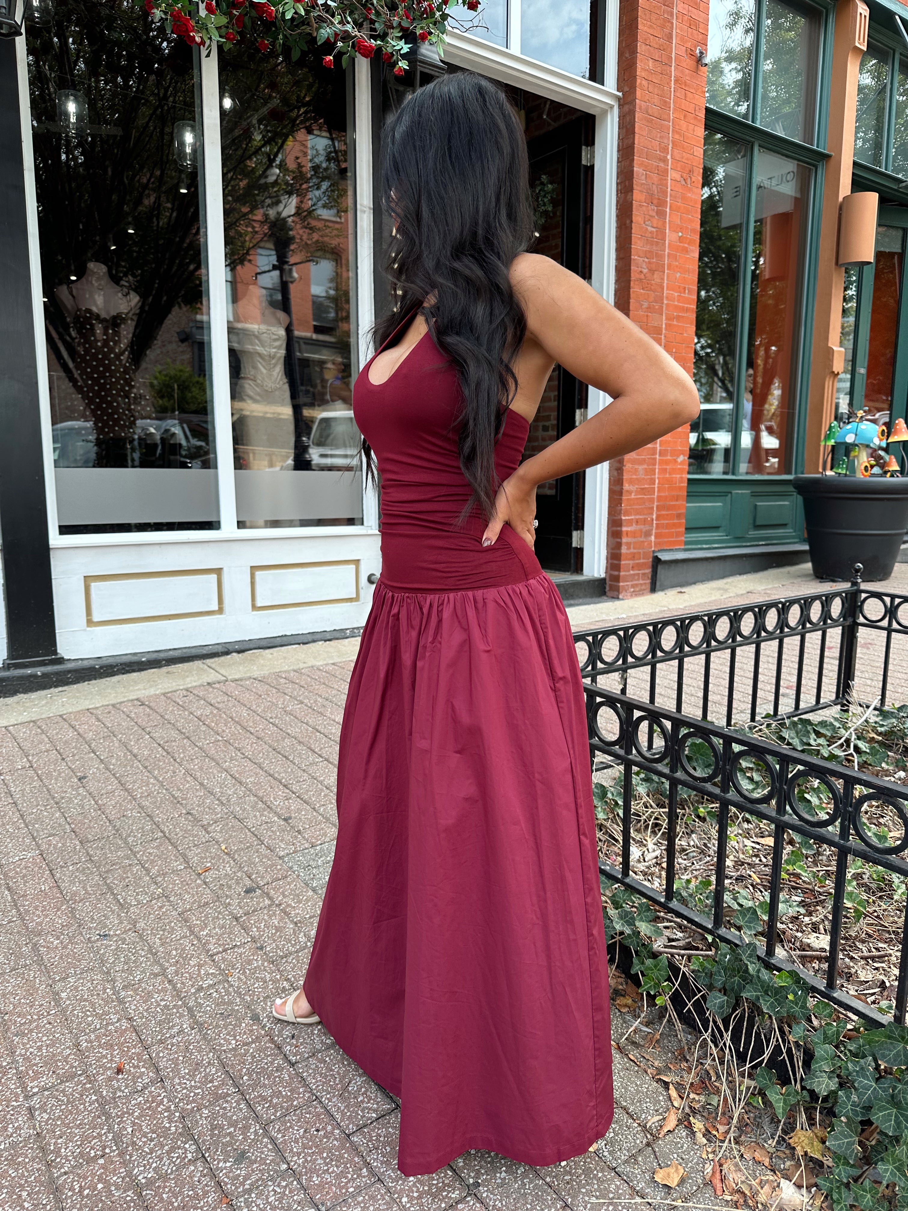 Woman wearing burgundy halter maxi dress with contrast material. 