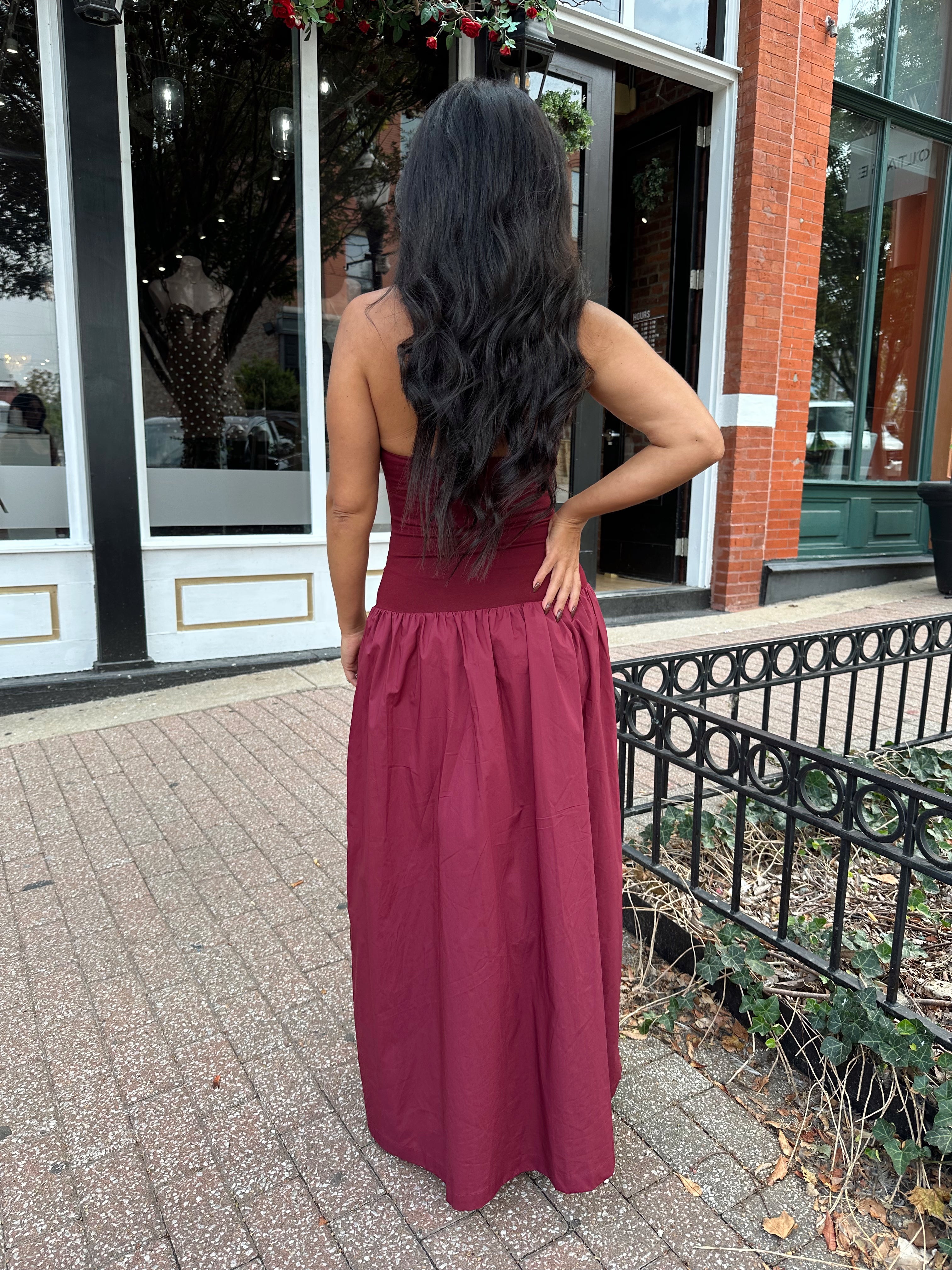 Woman wearing burgundy halter maxi dress with contrast material. 
