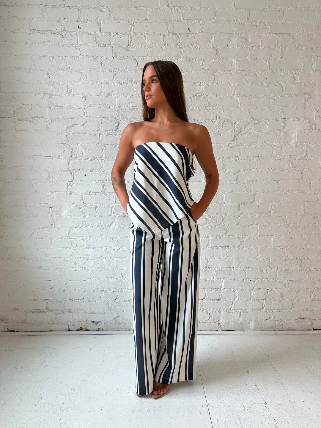 Woman wearing navy and white striped two piece set with open tie back.