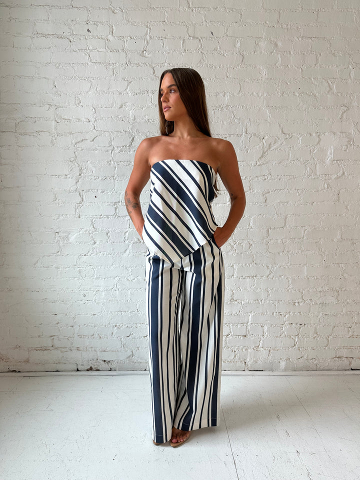 Woman wearing navy and white striped two piece set with open tie back.