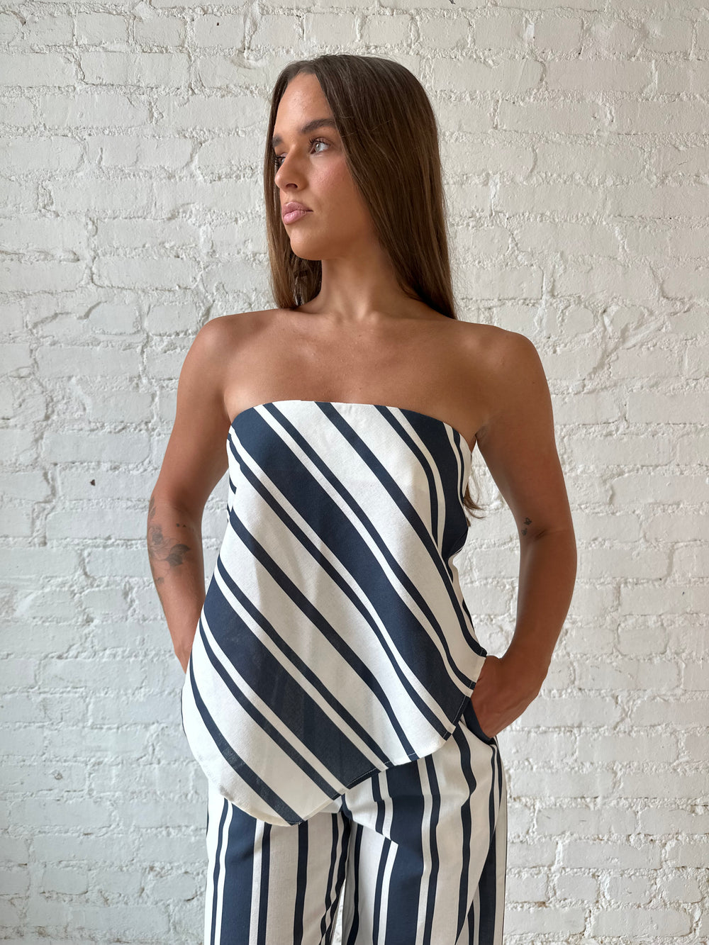 Woman wearing navy and white striped two piece set with open tie back.