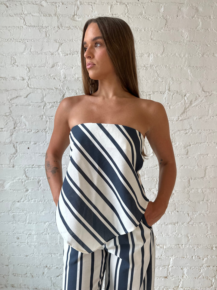 Woman wearing navy and white striped two piece set with open tie back.