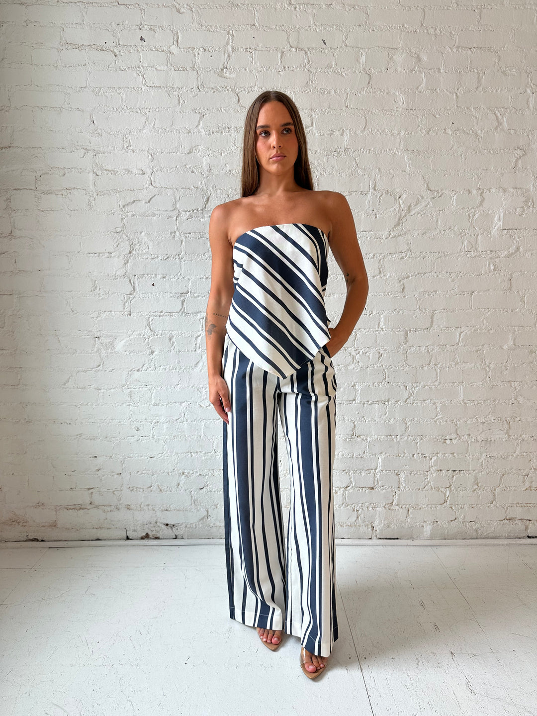 Woman wearing navy and white striped two piece set with open tie back.