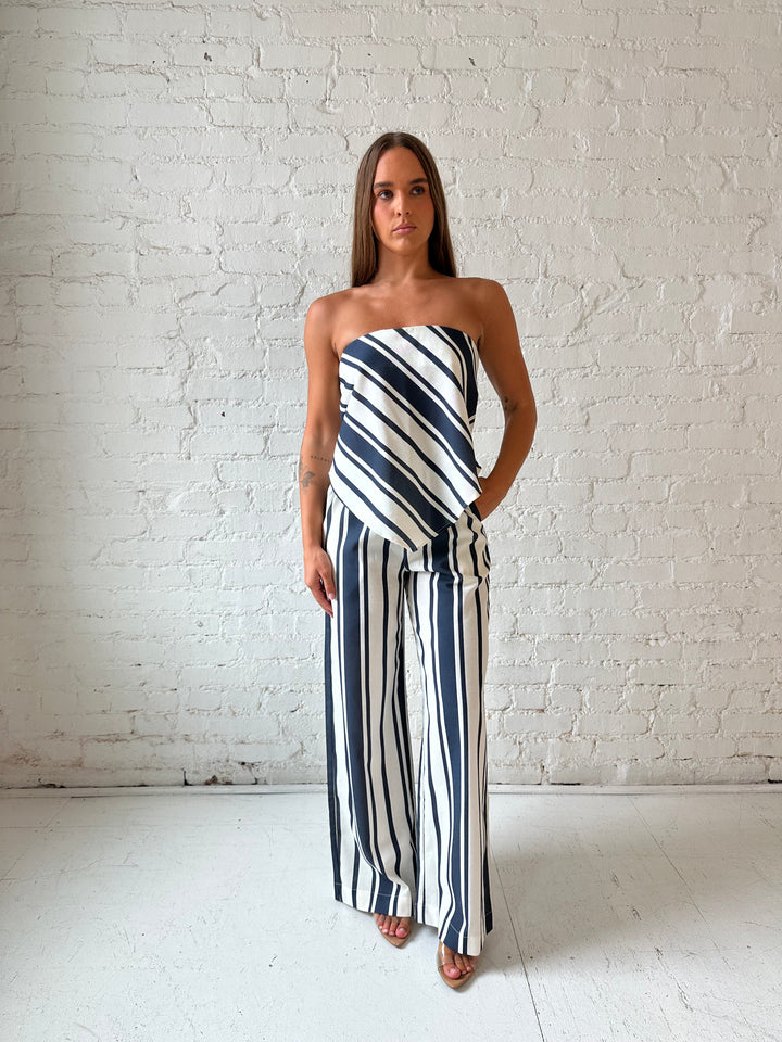 Woman wearing navy and white striped two piece set with open tie back.
