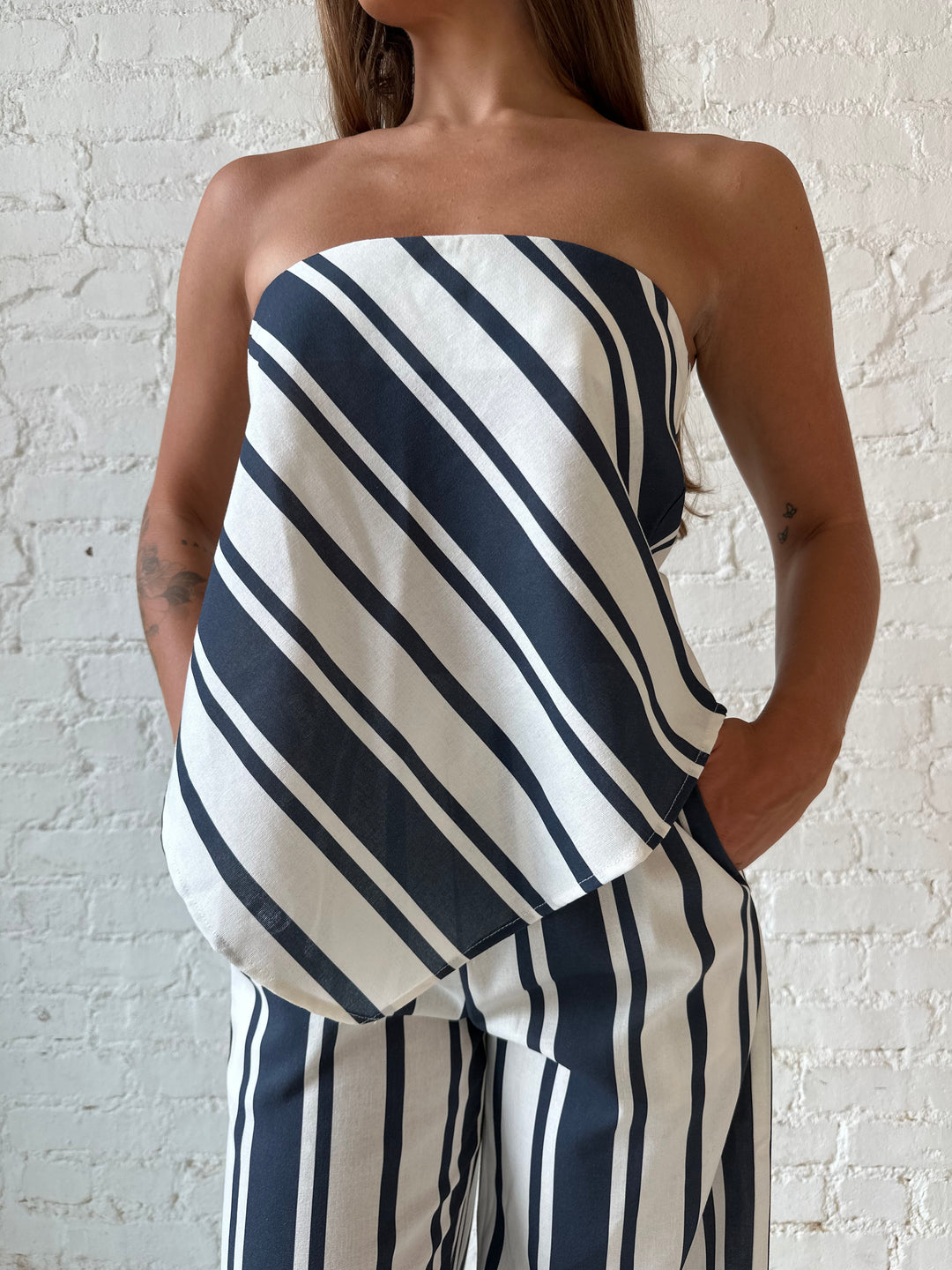 Woman wearing navy and white striped two piece set with open tie back.