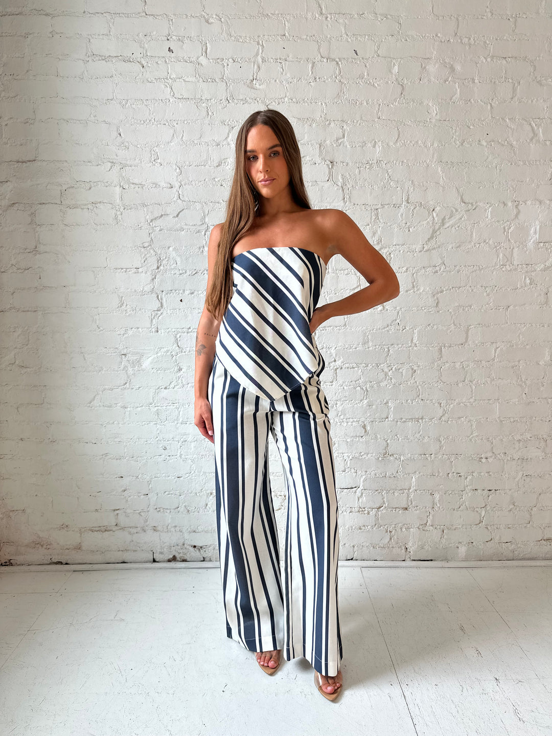 Woman wearing navy and white striped two piece set with open tie back.