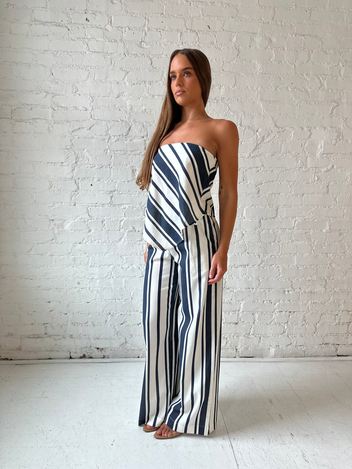 Woman wearing navy and white striped two piece set with open tie back.