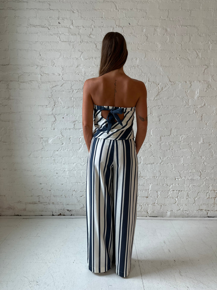 Woman wearing navy and white striped two piece set with open tie back.
