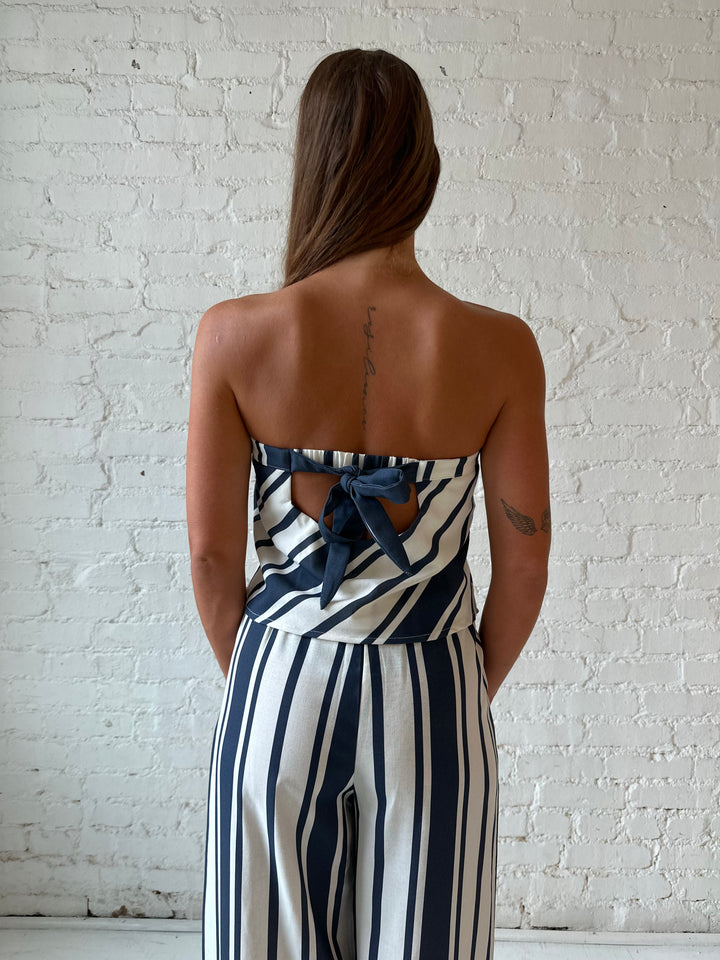 Woman wearing navy and white striped two piece set with open tie back.
