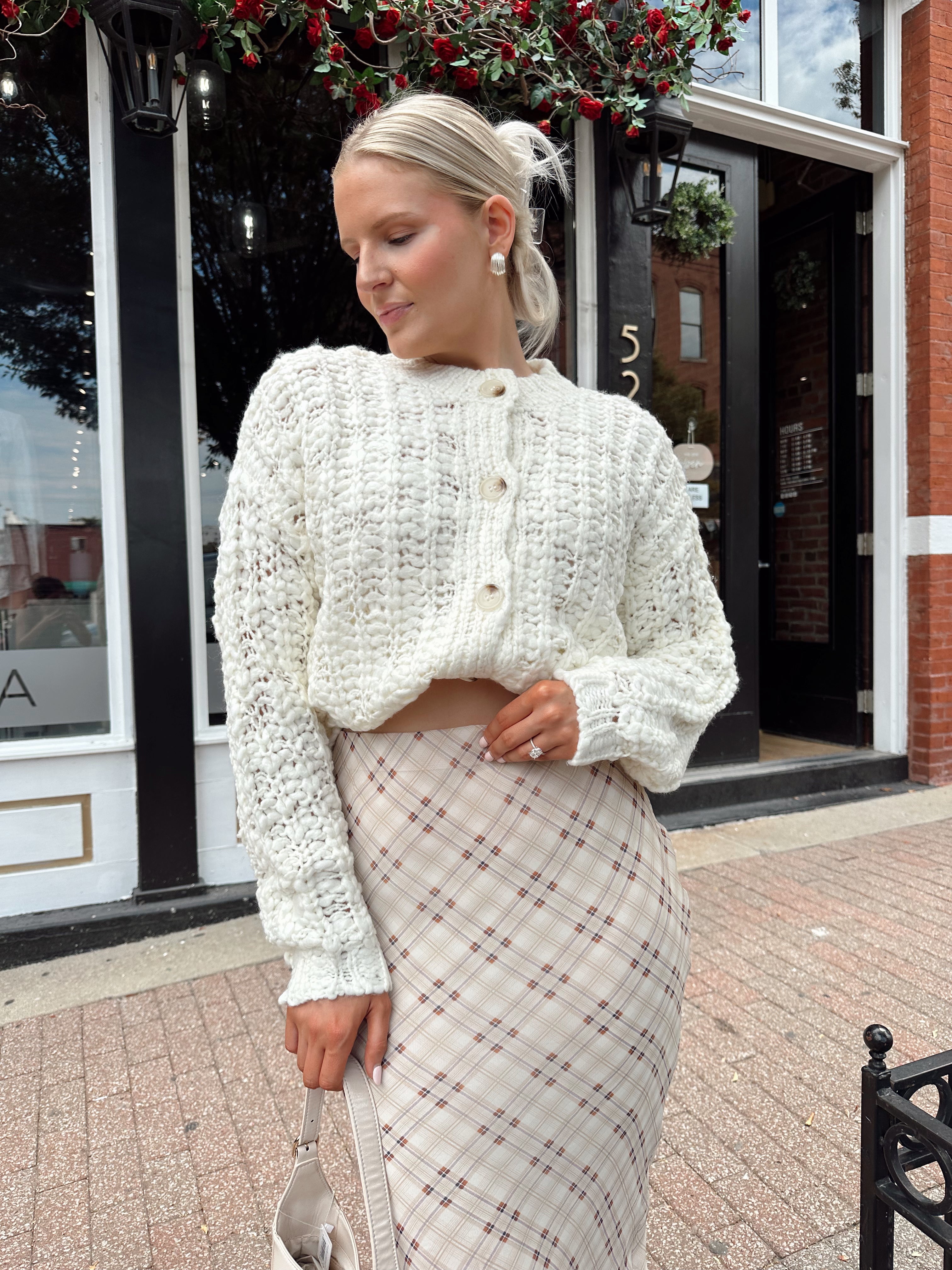 Cream colored chunky knit cardigan with tortuous shell buttons. 