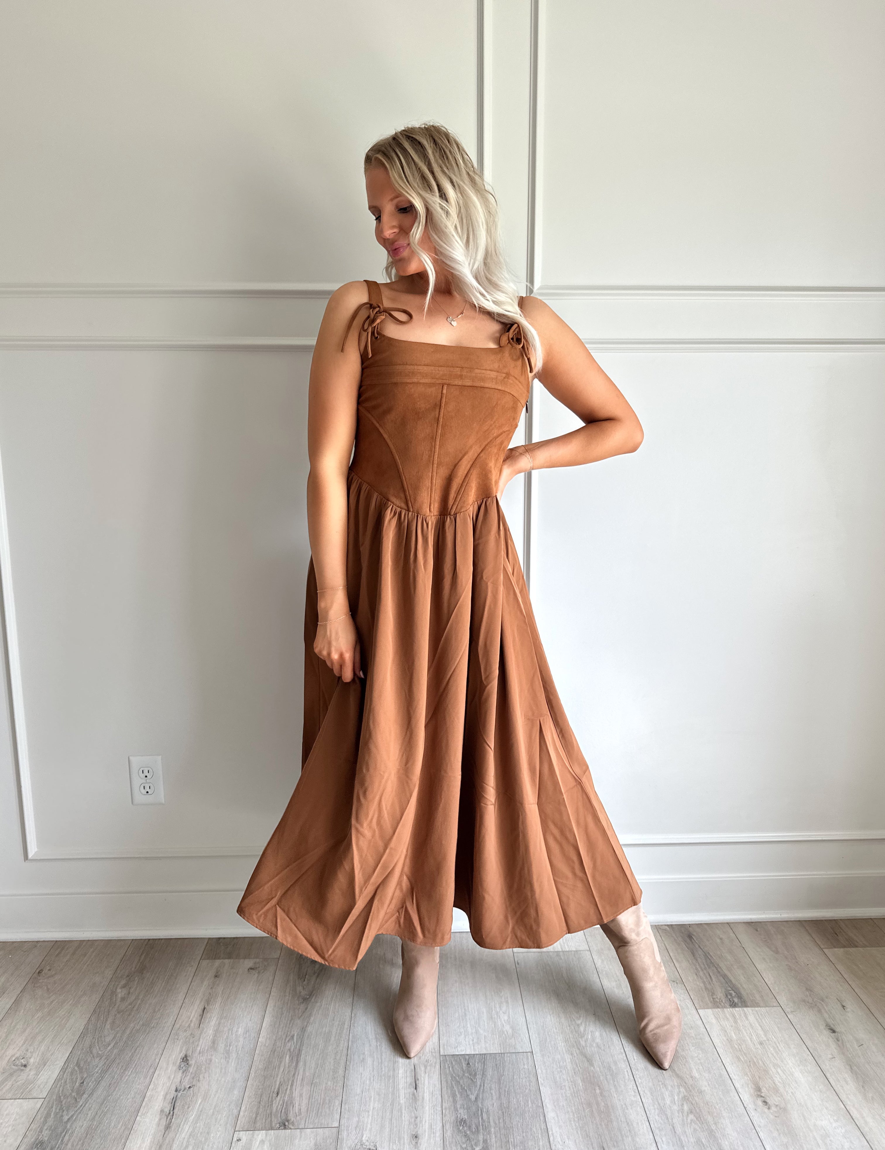 Woman wearing brown suede corset style midi dress with flowy skirt. 