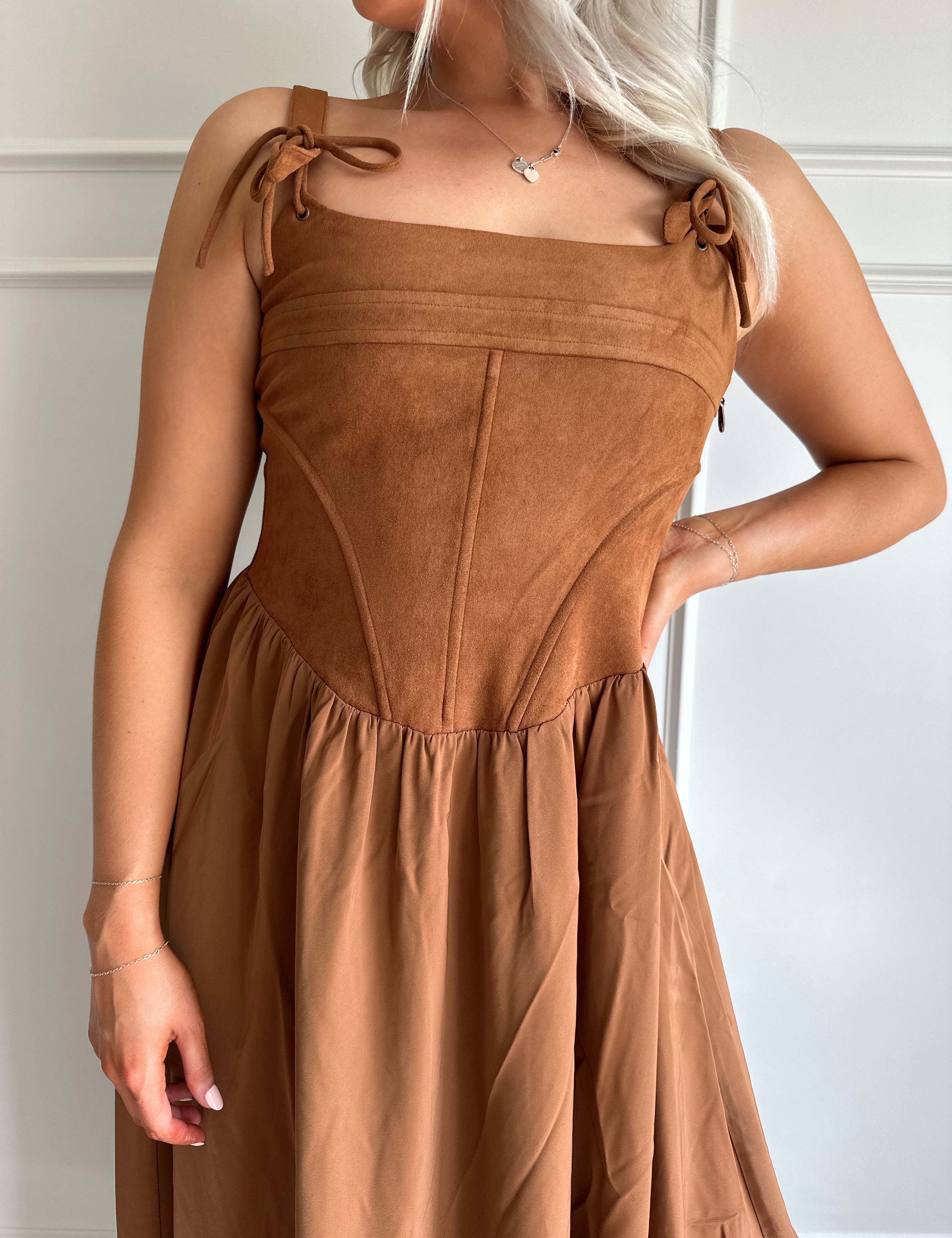 Woman wearing brown suede corset style midi dress with flowy skirt. 