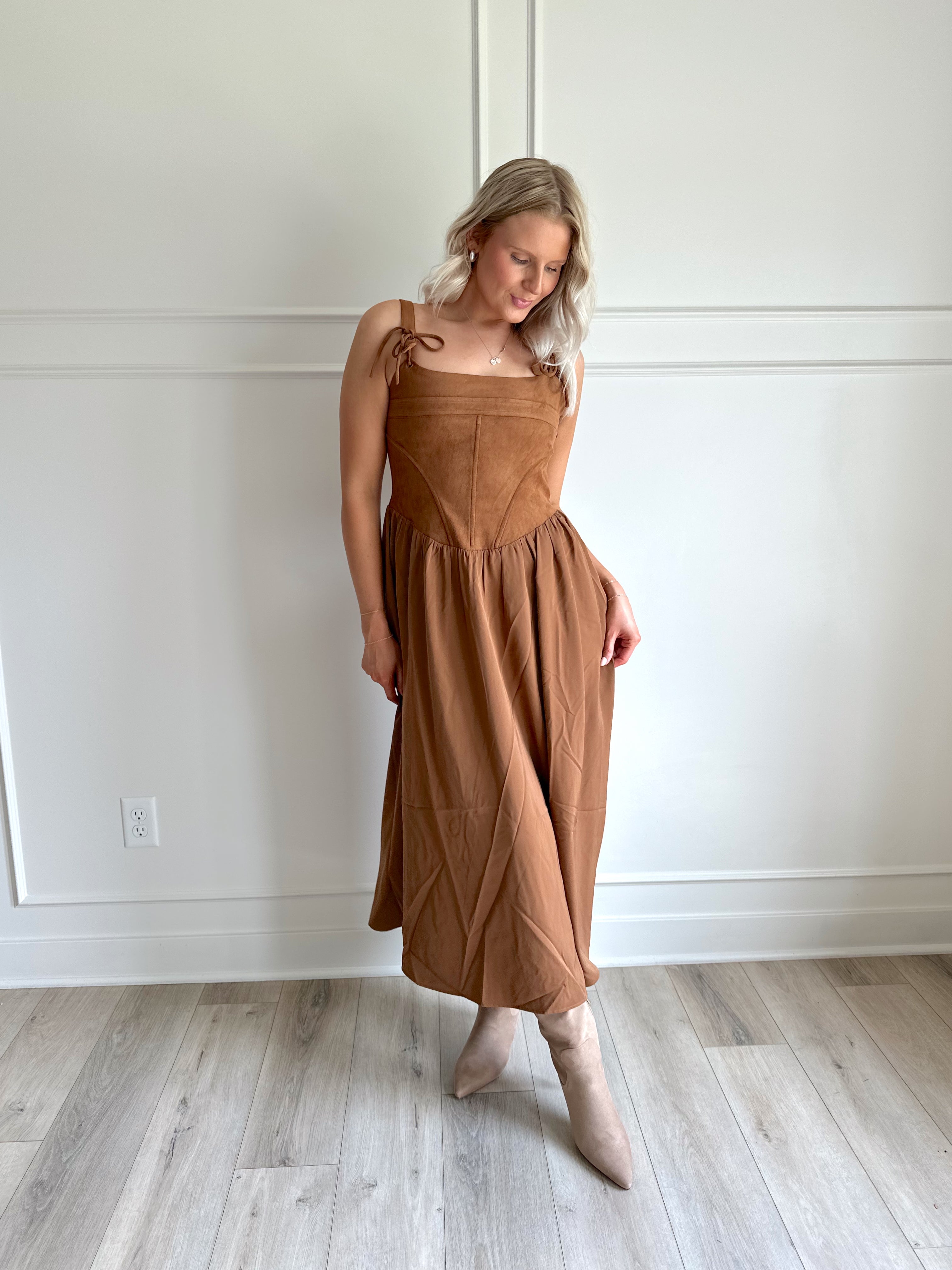 Woman wearing brown suede corset style midi dress with flowy skirt. 