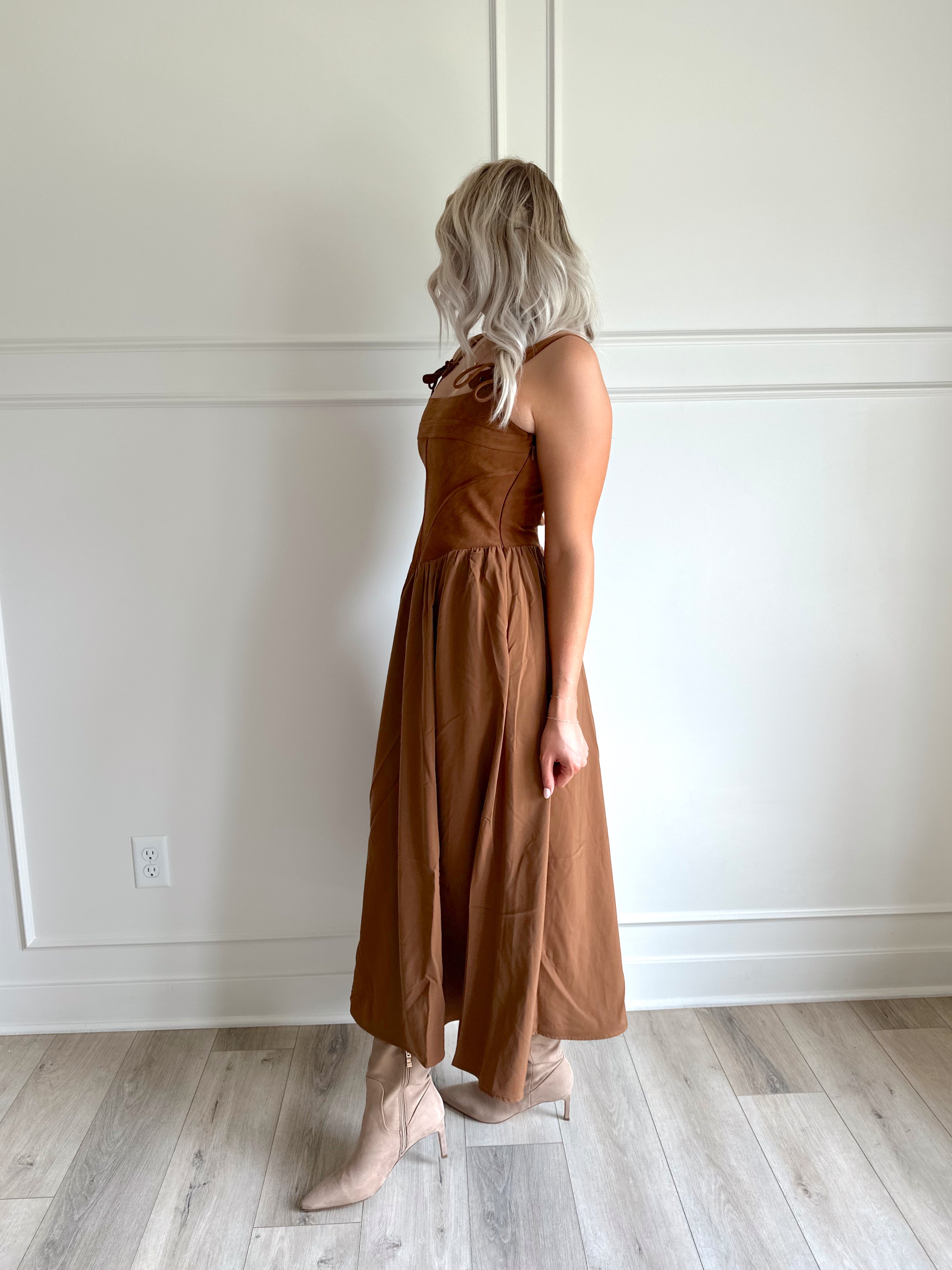 Woman wearing brown suede corset style midi dress with flowy skirt. 