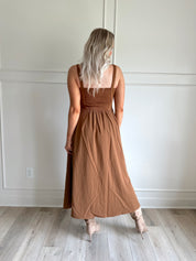 Woman wearing brown suede corset style midi dress with flowy skirt. 