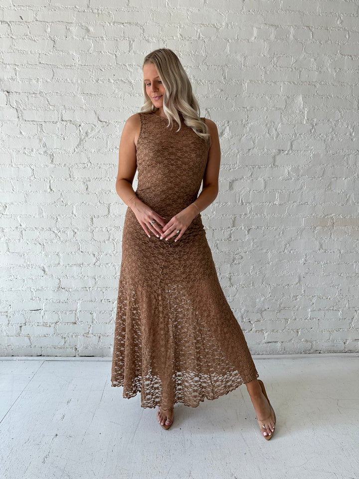 Woman wearing brown lace maxi dress with clear heels.