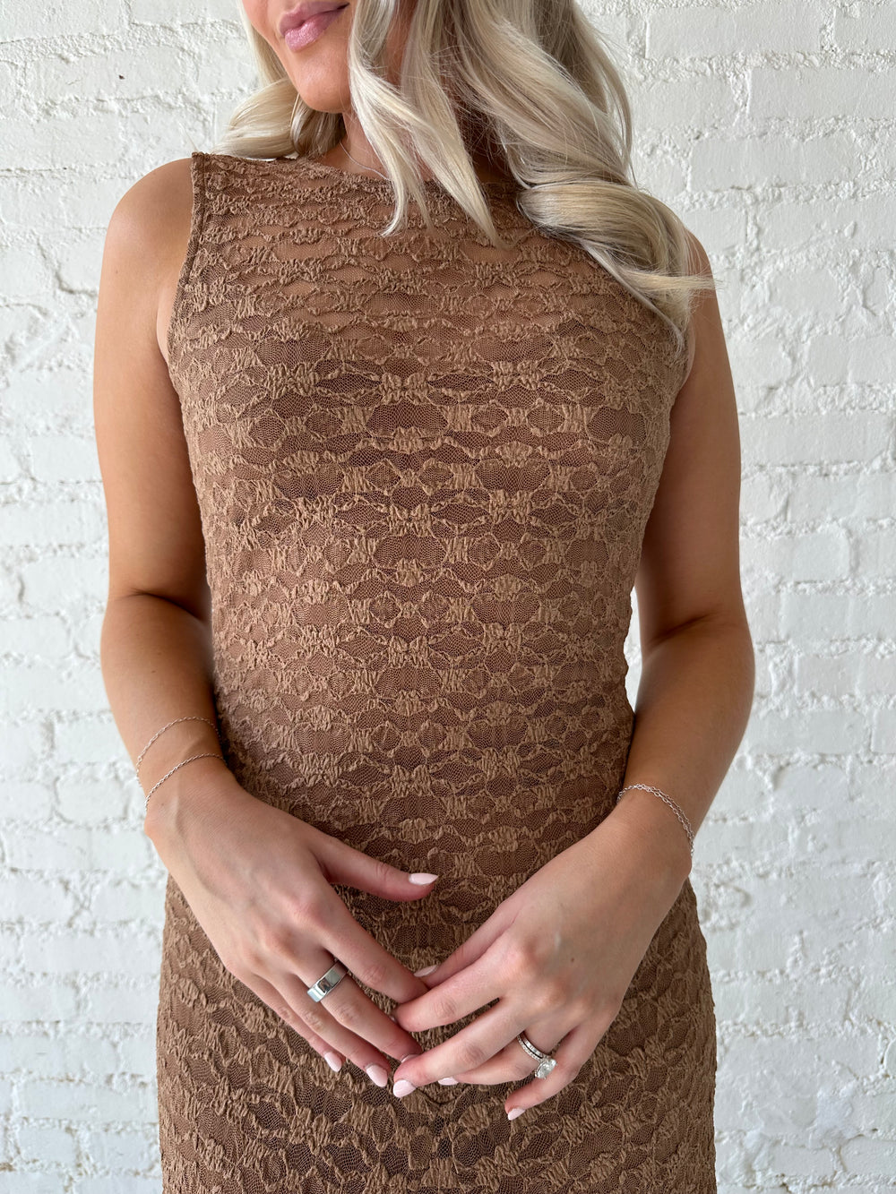 Woman wearing brown lace maxi dress with clear heels.
