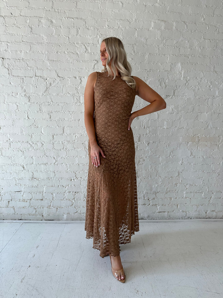 Woman wearing brown lace maxi dress with clear heels.