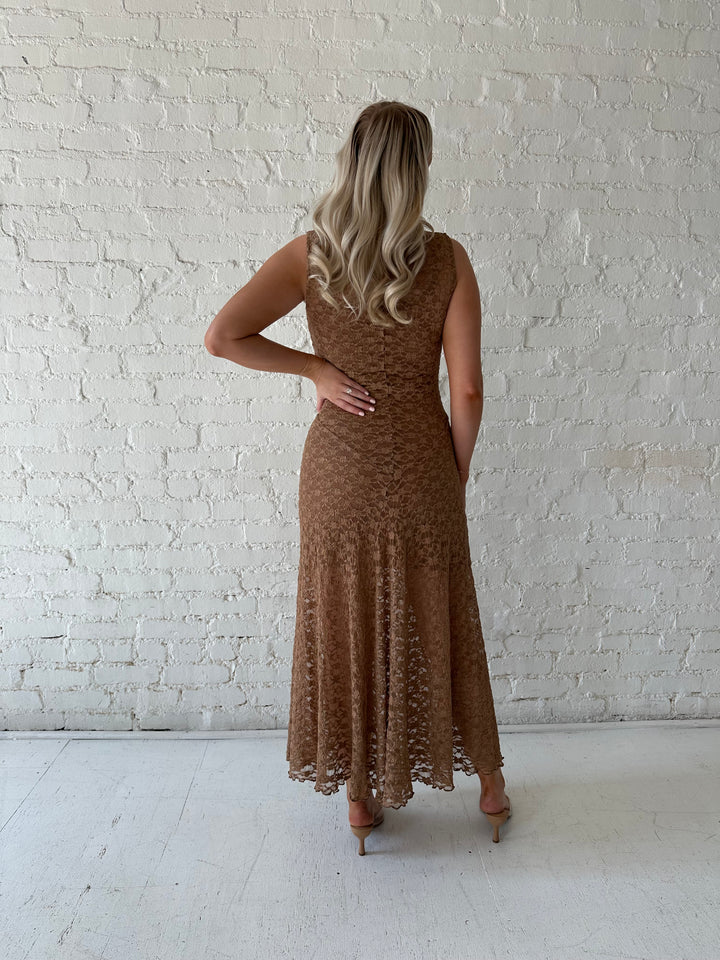 Woman wearing brown lace maxi dress with clear heels.