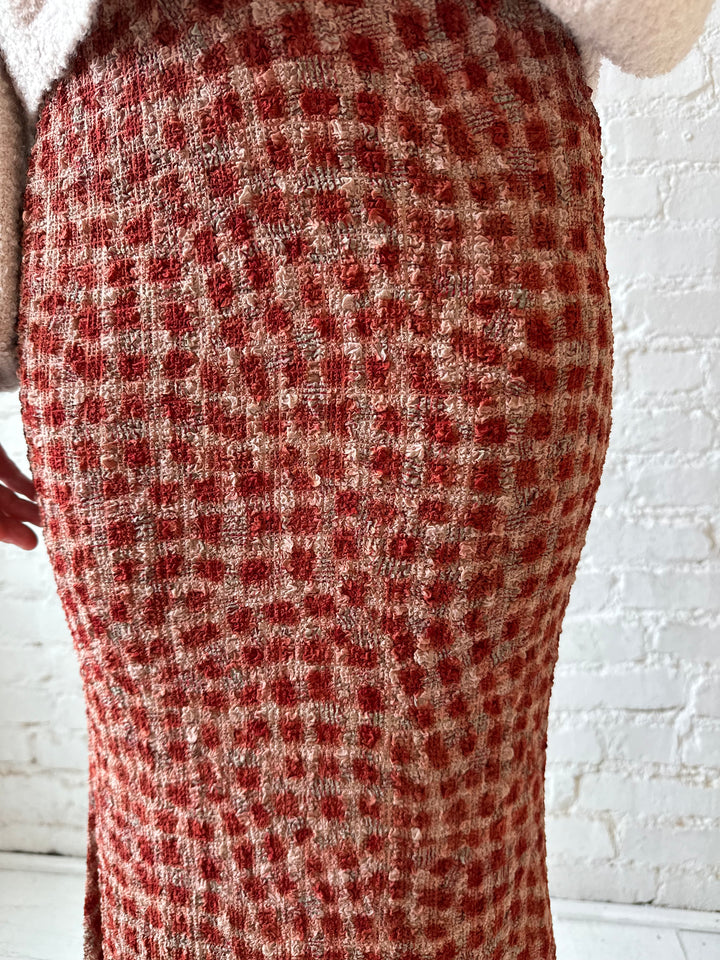 Woman wearing beige knit sweater with burgundy dotted maxi skirt.
