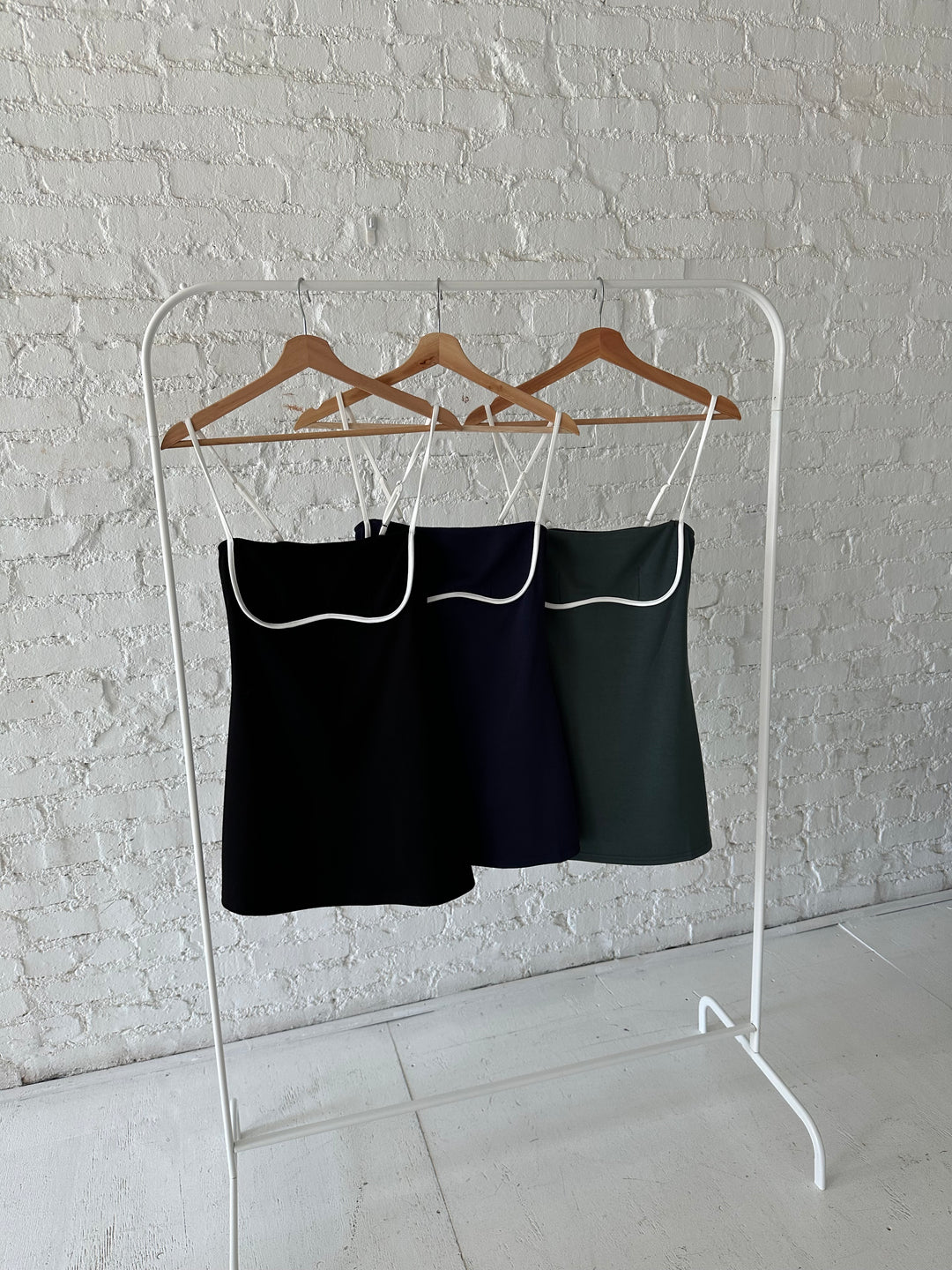 Black, dark green and navy athletic mini dresses with white contrast detailing. 